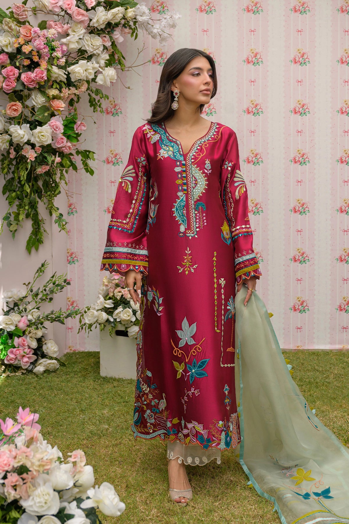 Full view of model in a magenta embroidered kurta with light green organza dupatta.